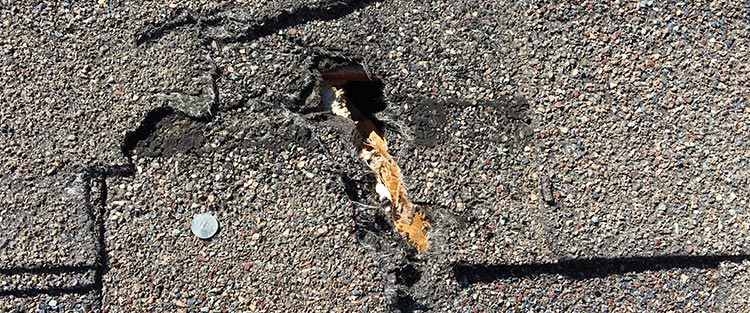 roof damage, hole in shingle roof